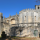 The Convent of Christ seen from the garden: the round Templar rotunda, crowned with battlements, adjoining the Manueline church and its balustraded terrace.